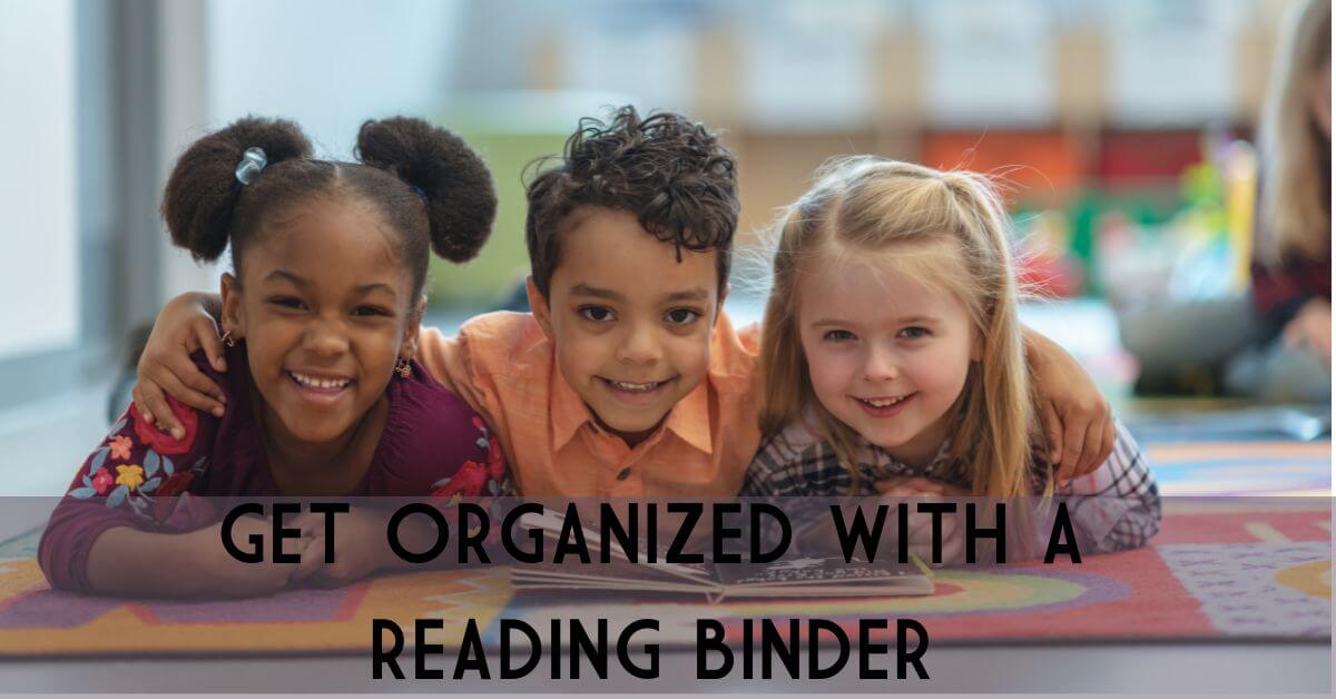 Three children laying on a carpet in a classroom. They are reading a book together. The boy in the middle has him arms around his two friends. The works are Get Organized with a Reading Binder.